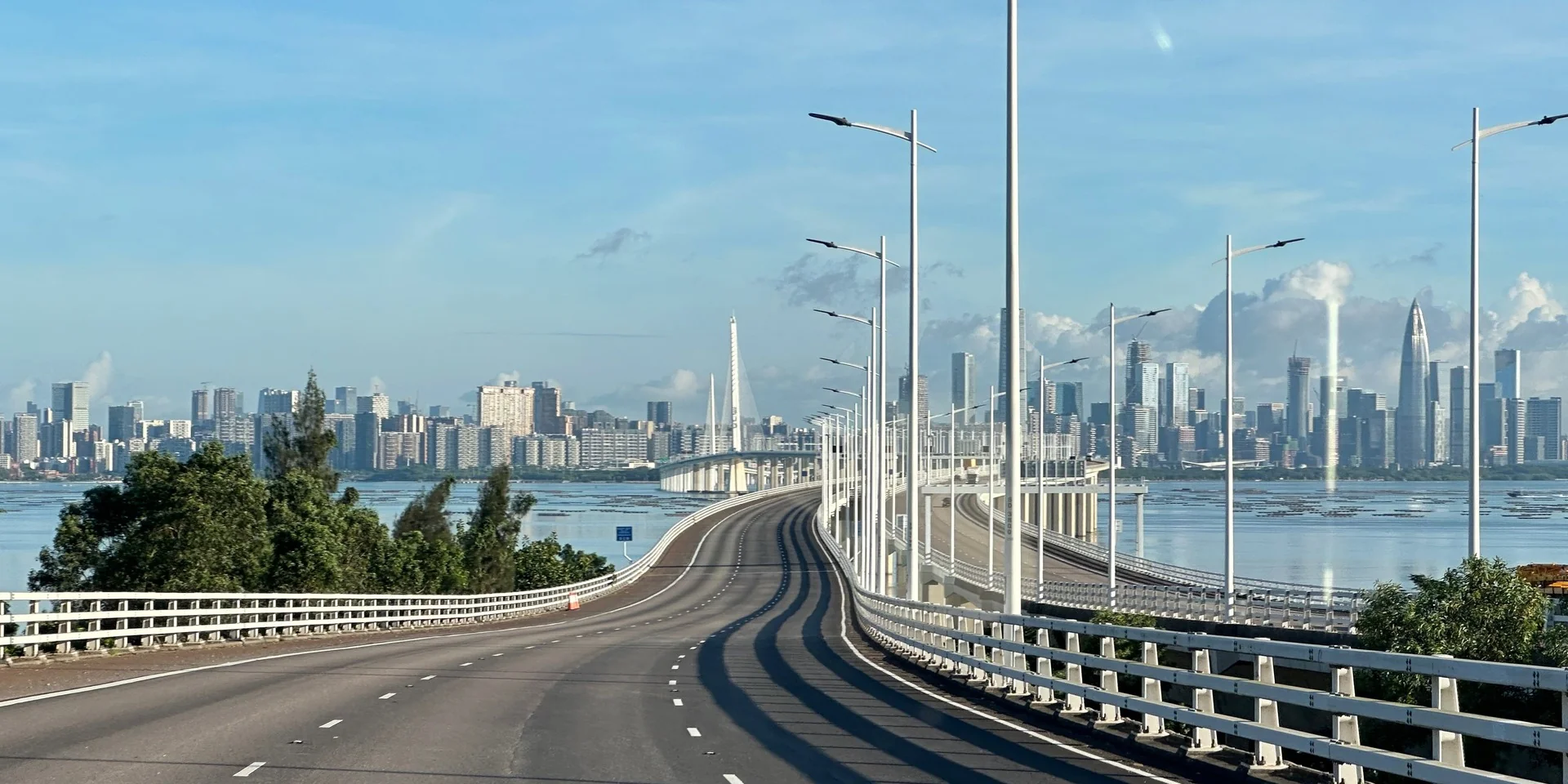 Private highway approach toward a Pearl River Delta skyline on a sourcing-trip transfer day